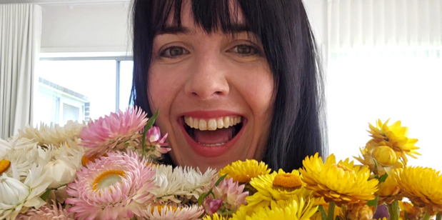 Person with a bouquet of flowers in front of their face