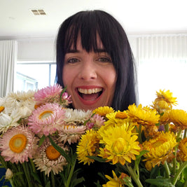 Person holding a bouquet of flowers with a bright smile
