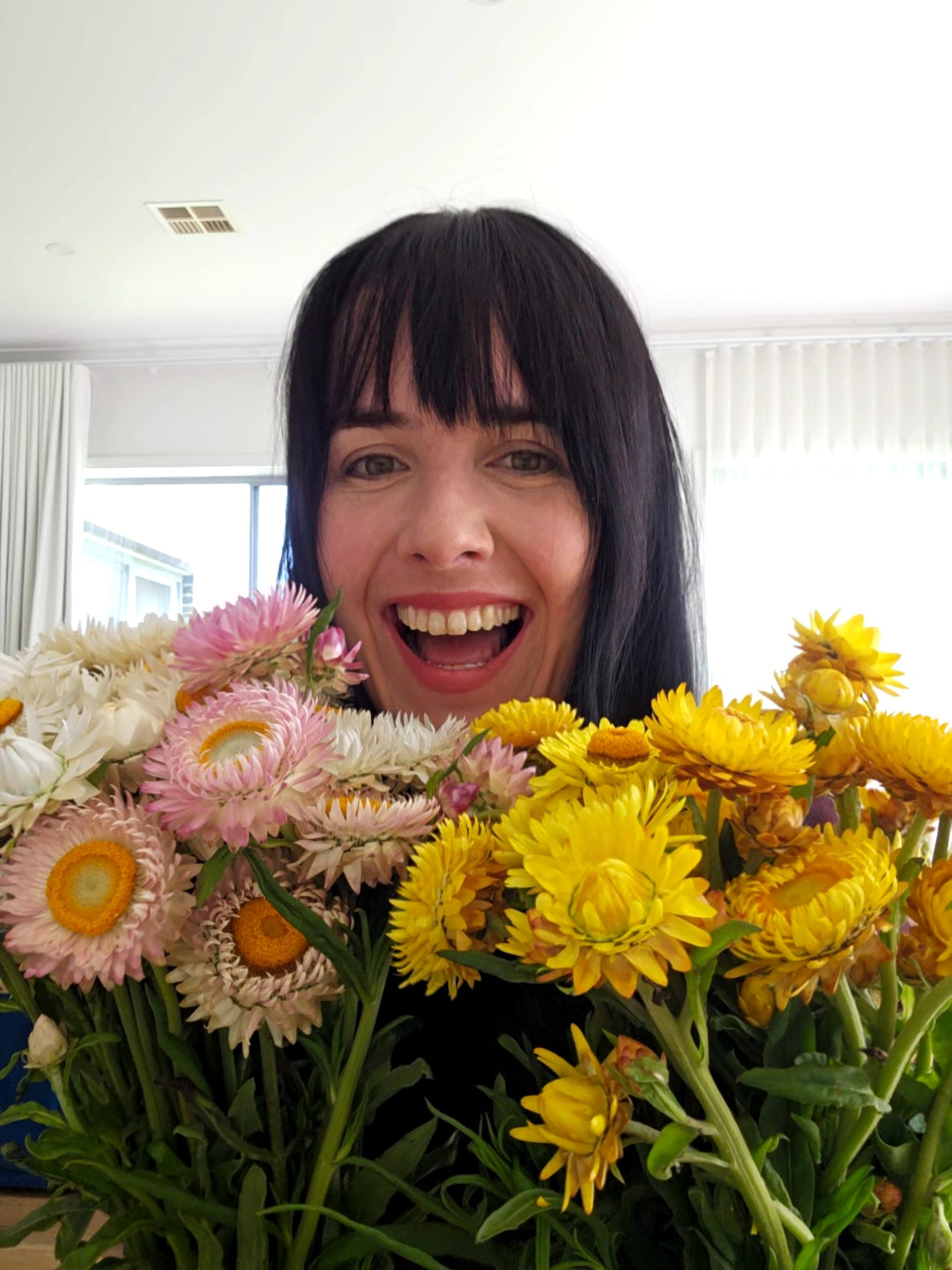 Person holding a bouquet of flowers with a bright smile