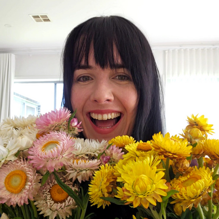 Person with a bouquet of flowers in front of their face