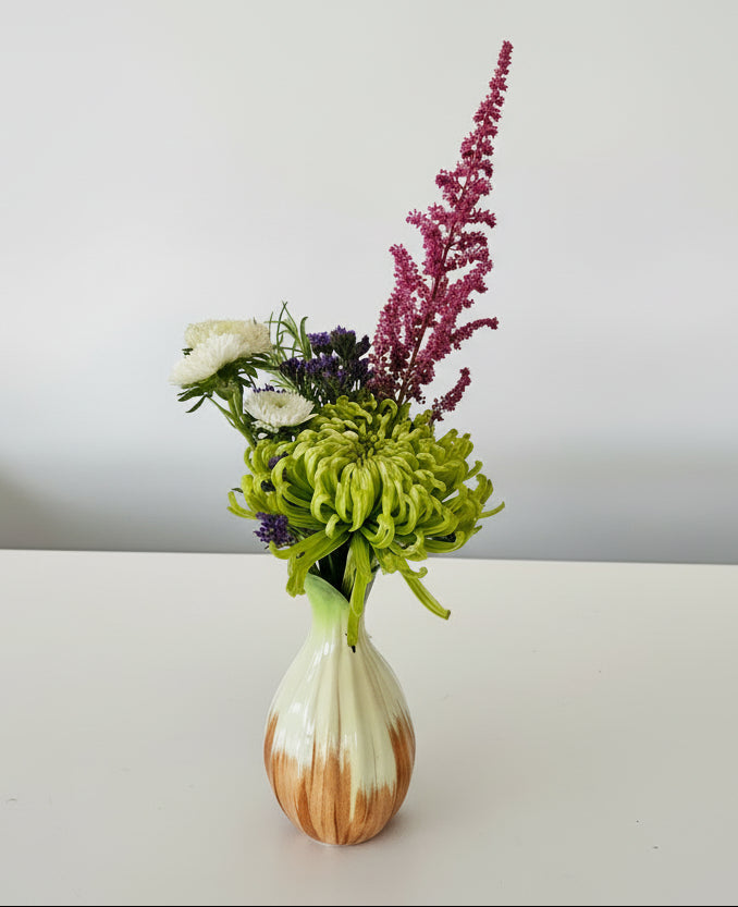 orange and white bud vase with flowers