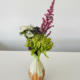 orange and white bud vase with flowers