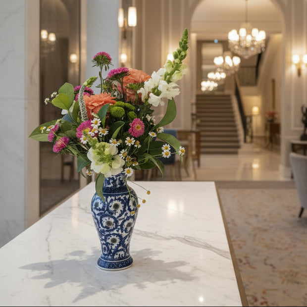 pink and peach flowers in a blue and white patterned ceramic vase
