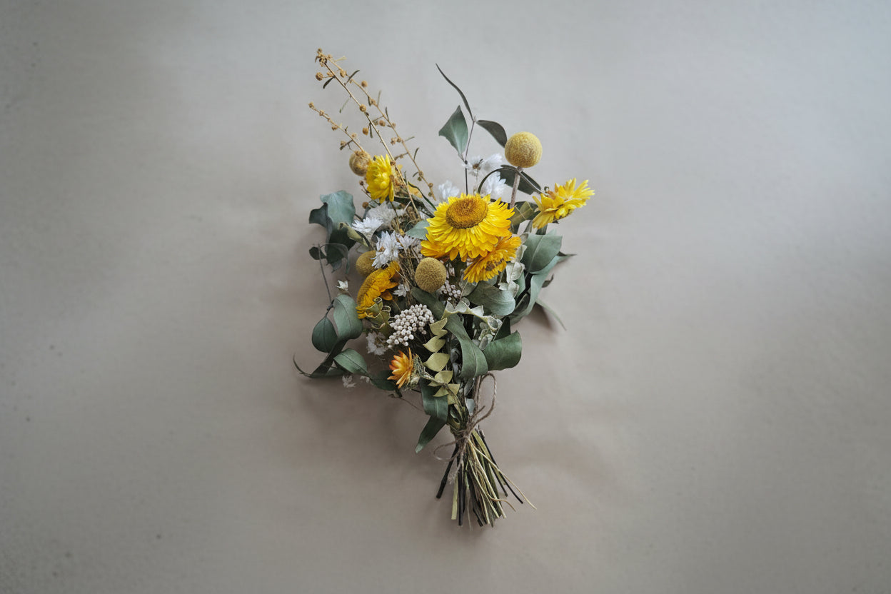 Bouquet of yellow flowers and greenery on a beige background