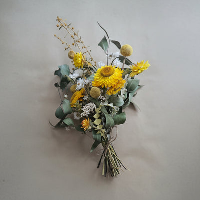 Bouquet of yellow flowers and greenery on a beige background