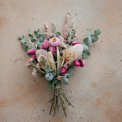 Bouquet of dried flowers and greenery on a beige background