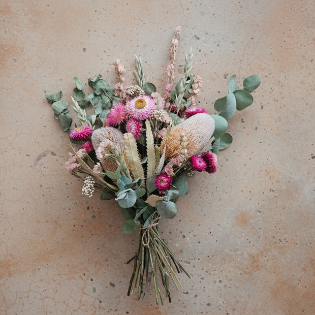 Bouquet of dried flowers and greenery on a beige background
