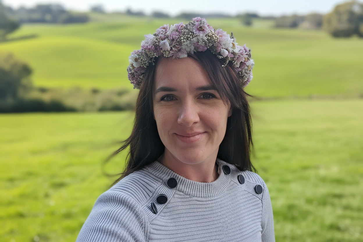 Person wearing a floral headband with a blurred outdoor background