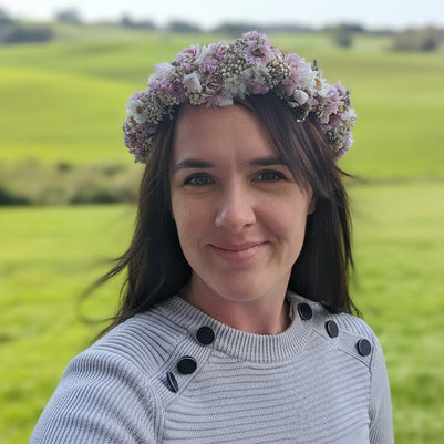 Person wearing a floral headband with a blurred outdoor background