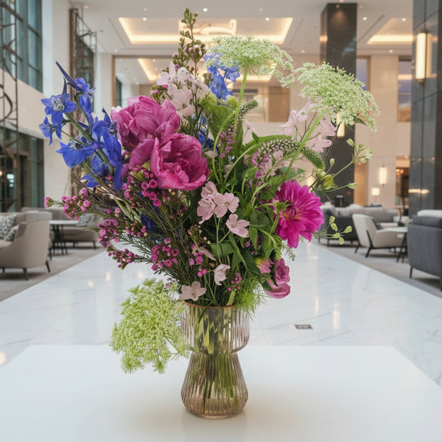 Pink and green flower arrangement on a white table 