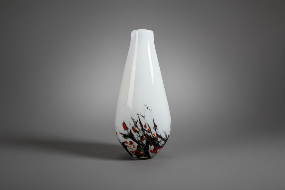 White vase with black and orange abstract design on a white background