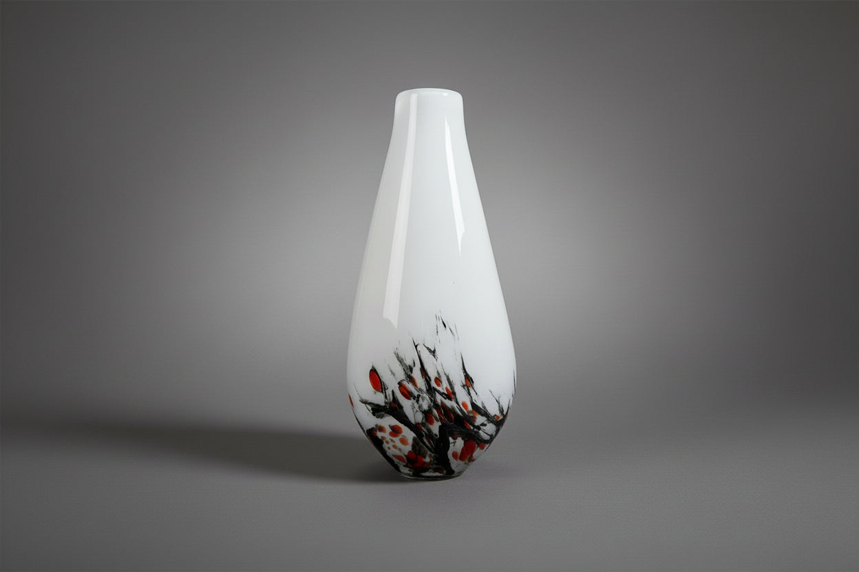 White vase with black and orange abstract design on a white background