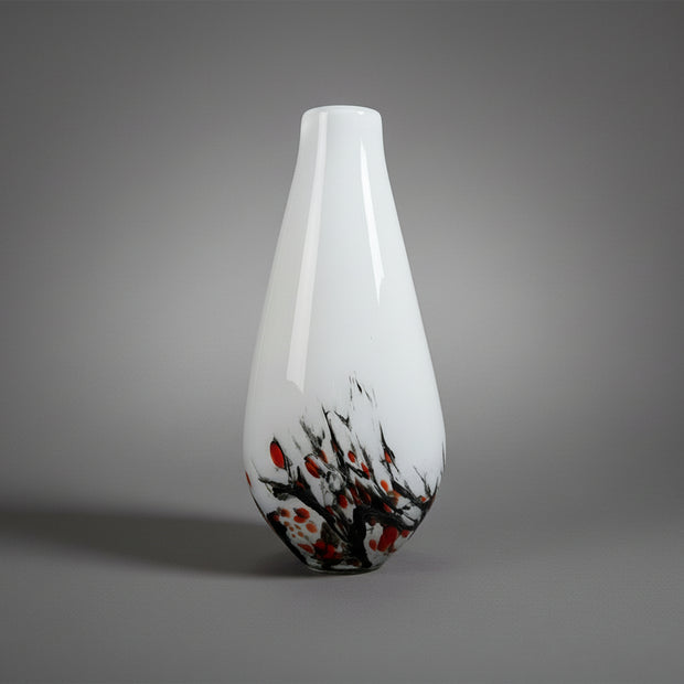 White vase with black and orange abstract design on a white background