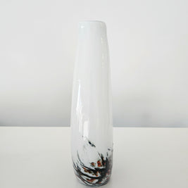Tall cylindrical vase with black and orange abstract design on a white background
