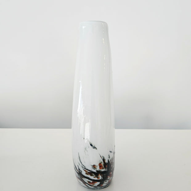 Tall cylindrical vase with black and orange abstract design on a white background