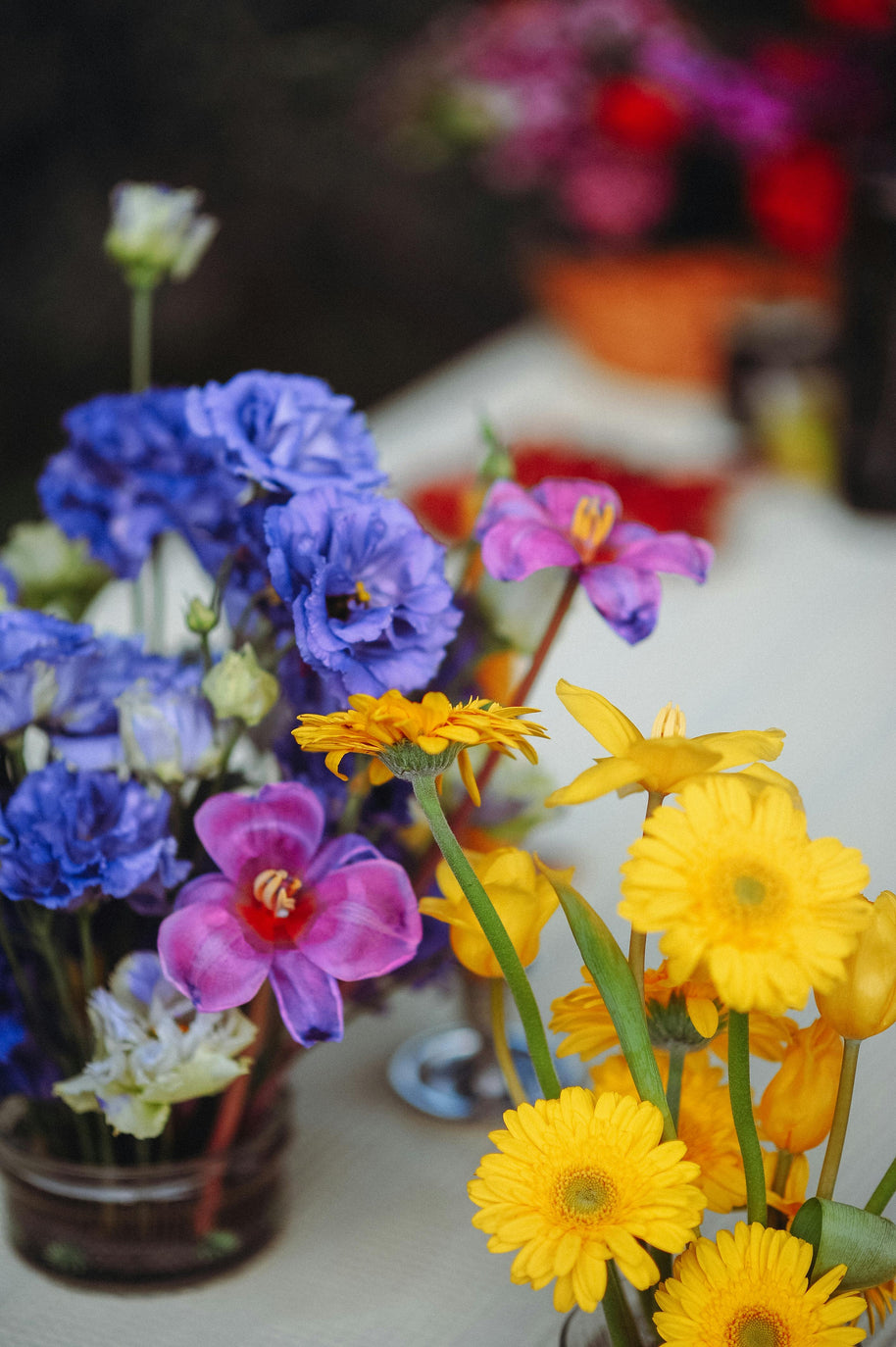 Colourful flower arrangement with yellow, purple, and blue flowers on a blurred background