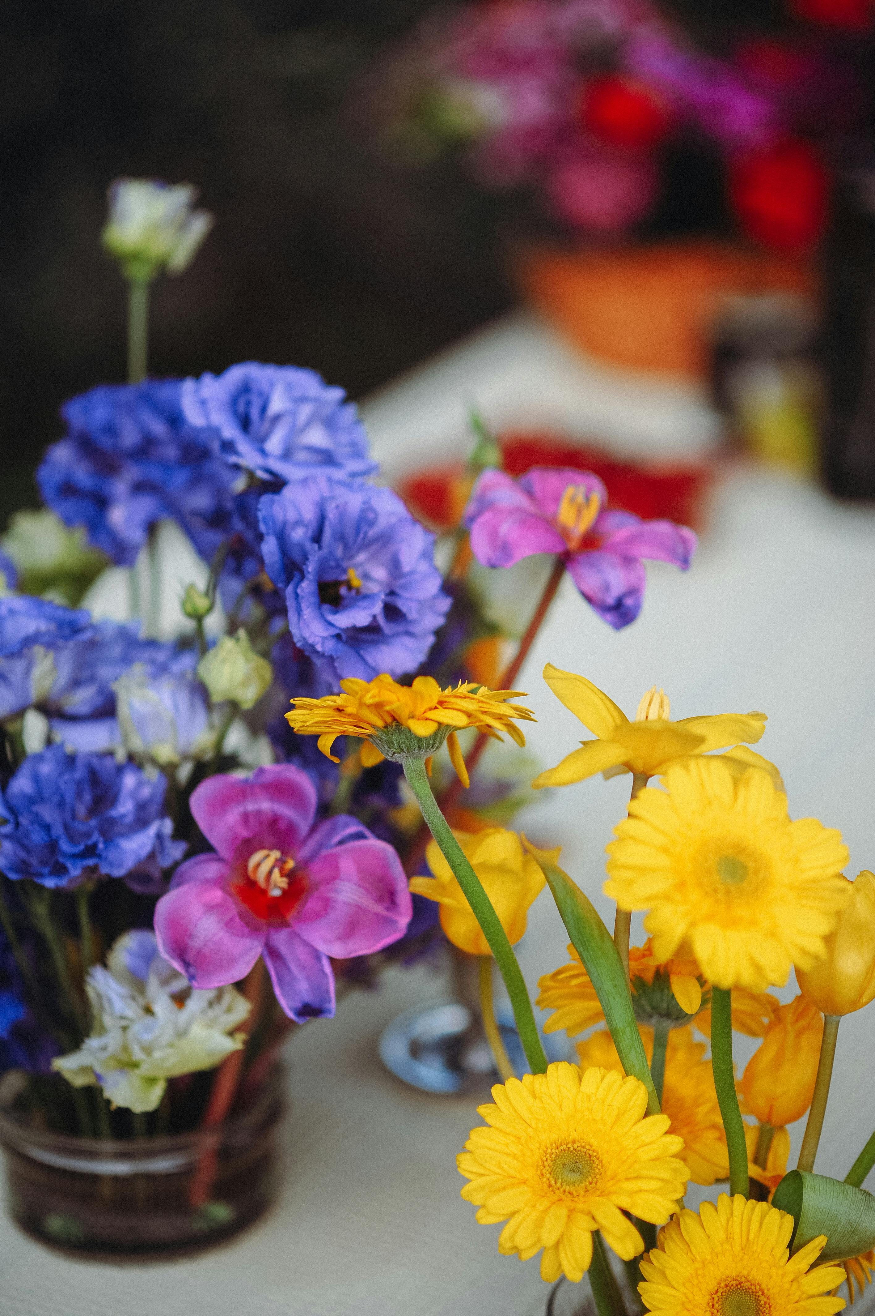 Colourful flower arrangement with yellow, purple, and blue flowers on a blurred background