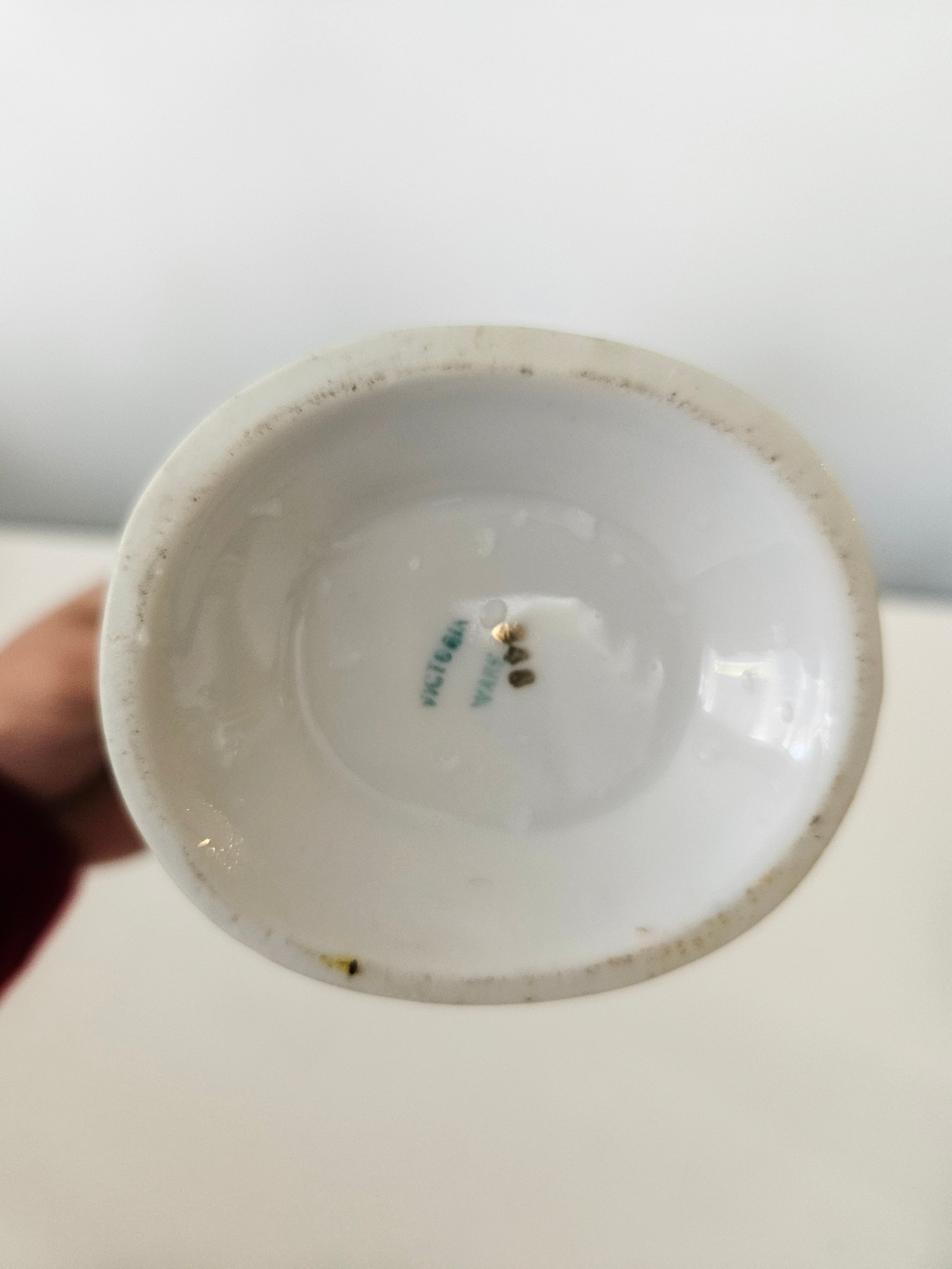 Close-up of a ceramic vase with visible branding on a white background