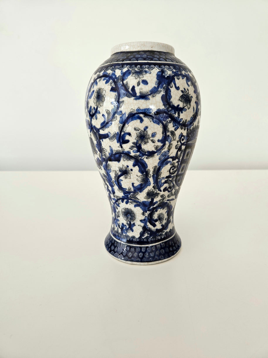Ceramic vintage vase with blue and white floral patterns on a white background