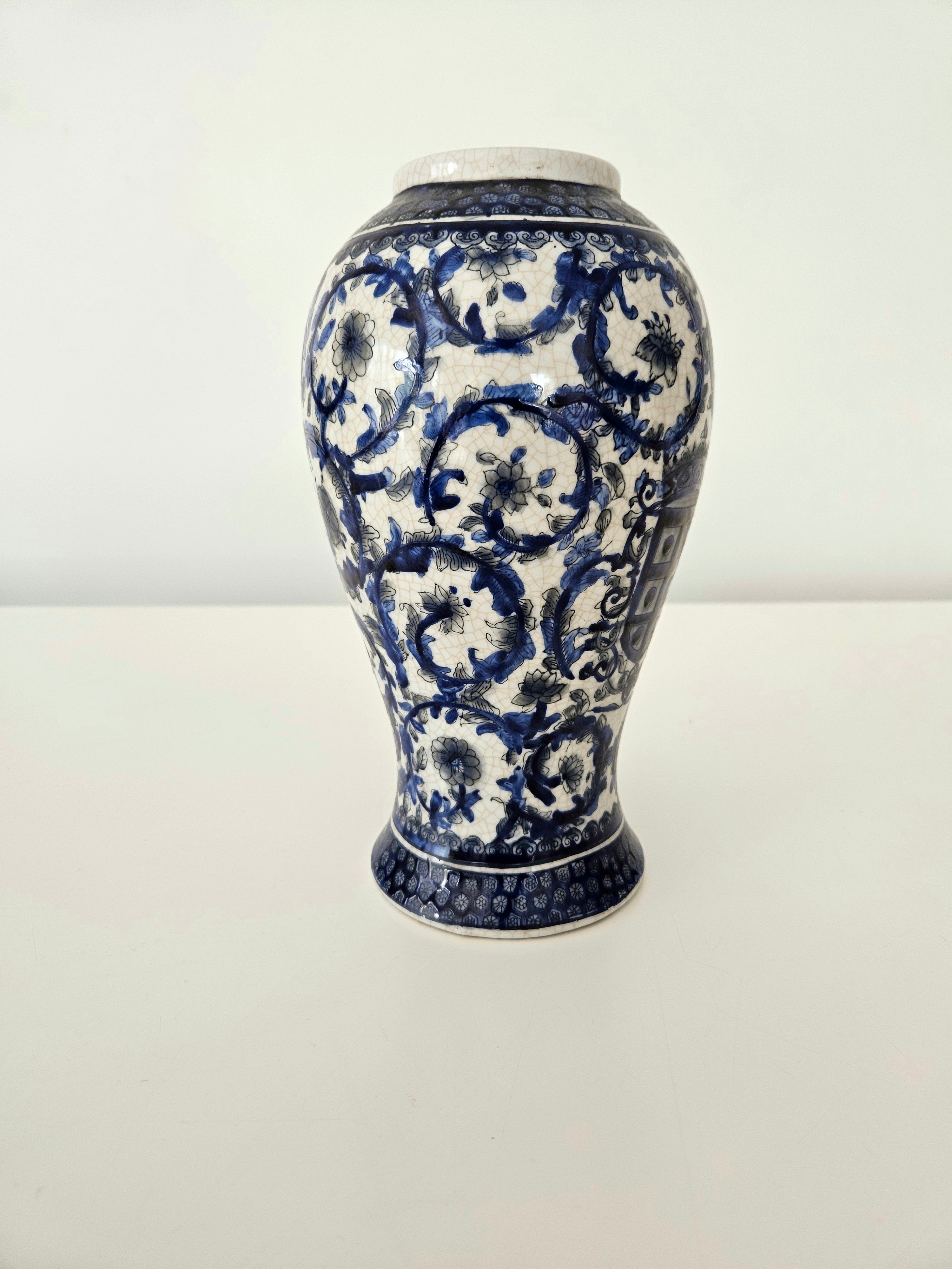 Ceramic vintage vase with blue and white floral patterns on a white background