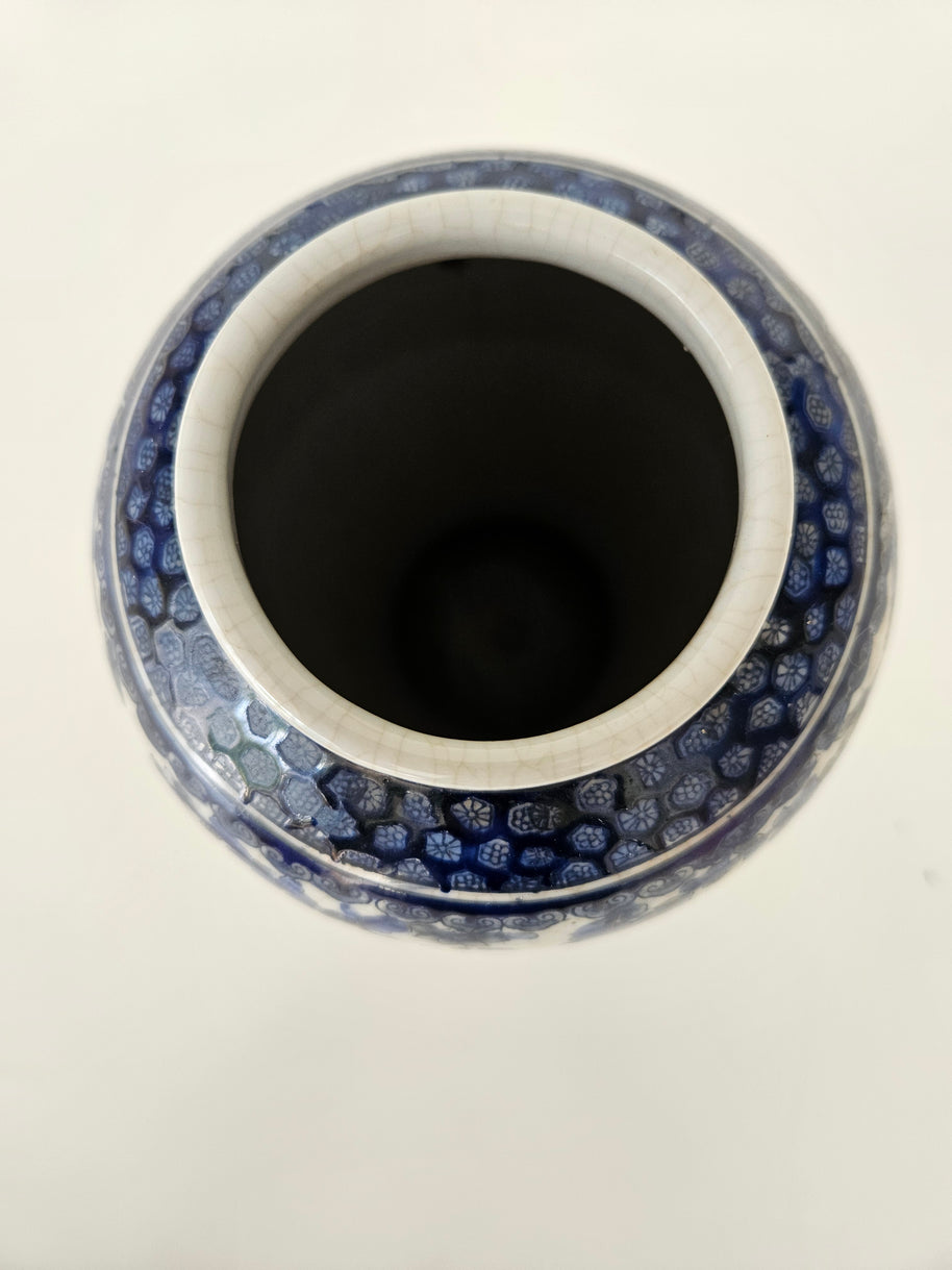 Top down view of a ceramic vase with a blue and white pattern on a white background