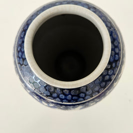 Top down view of a ceramic vase with a blue and white pattern on a white background