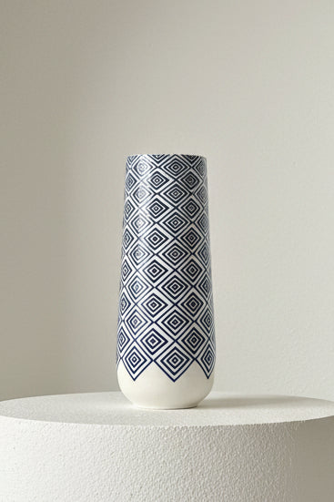 blue and white vase on a table