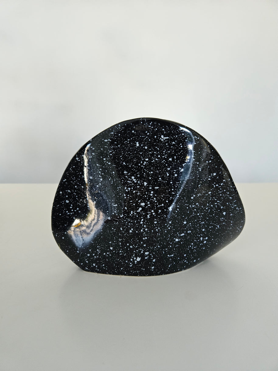 Black speckled stone on a light grey background