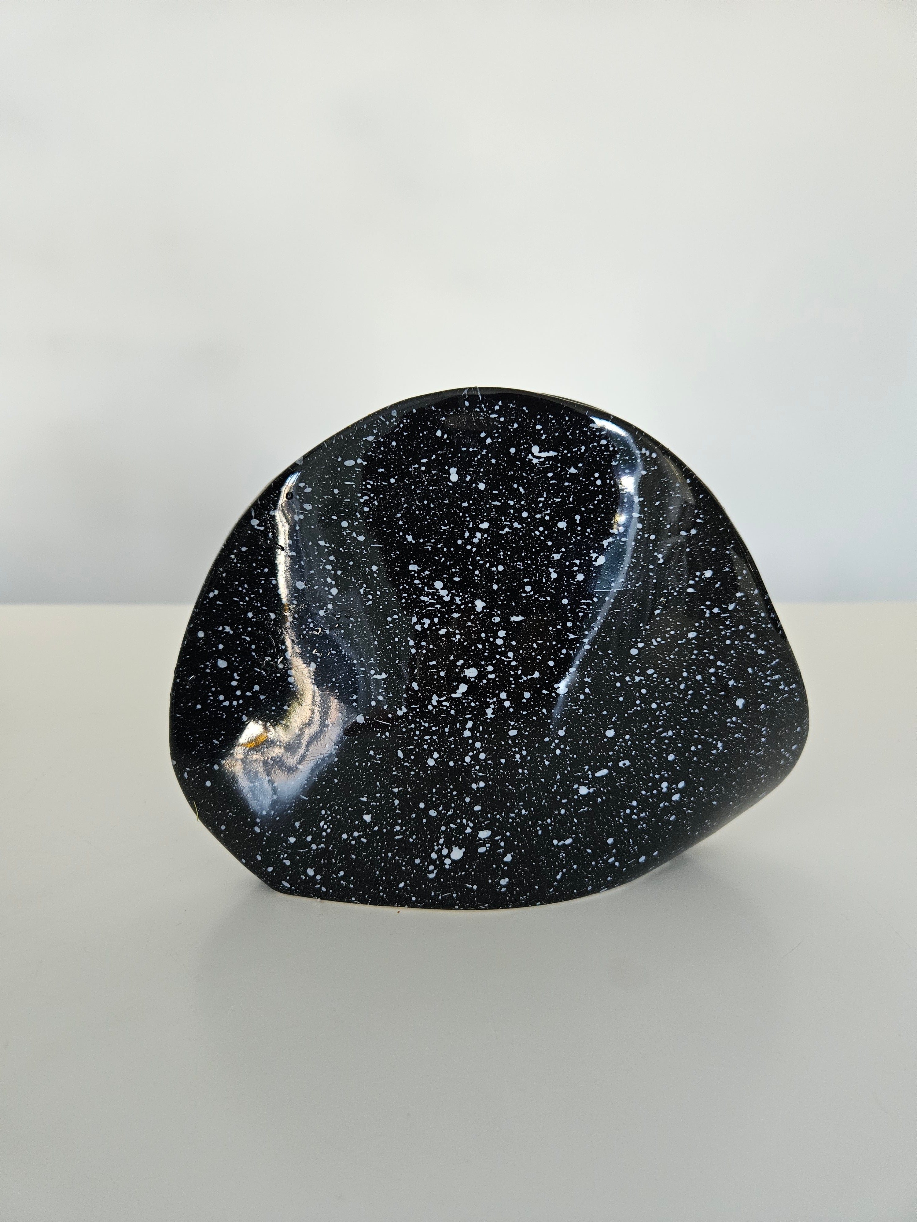 Black speckled stone on a light grey background