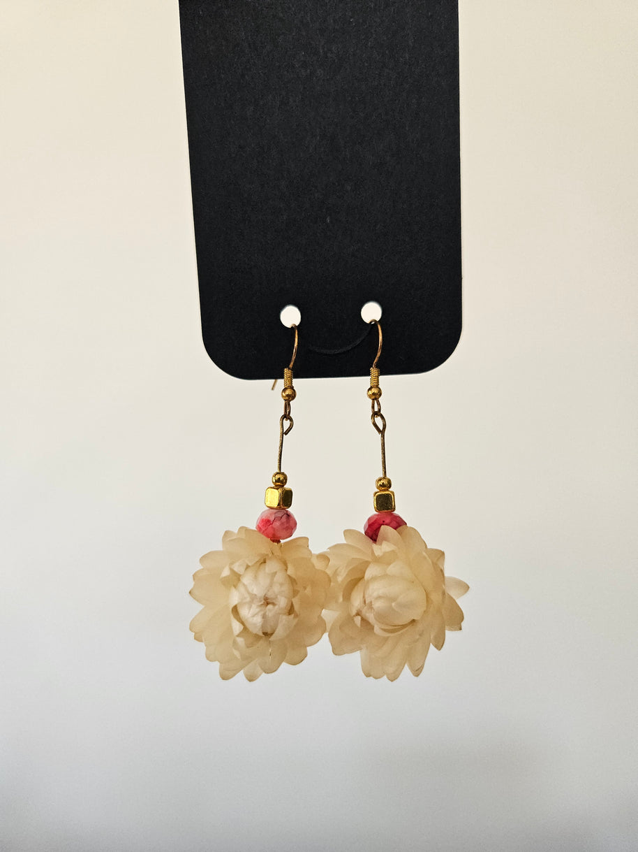 Floral earrings on a black card with a light gray background