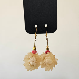 Floral earrings on a black card with a light gray background