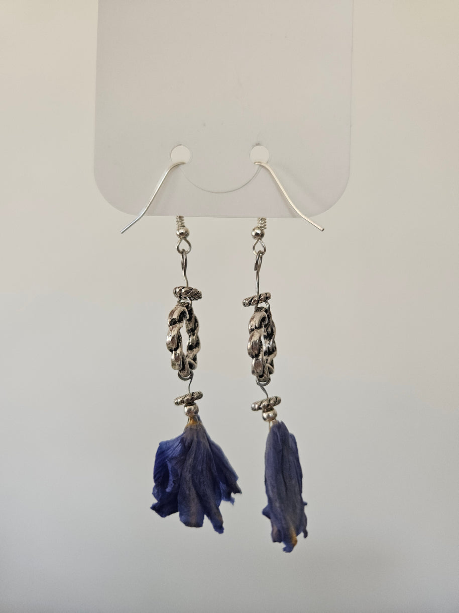 Pair of earrings with blue flowerpendants on a white background