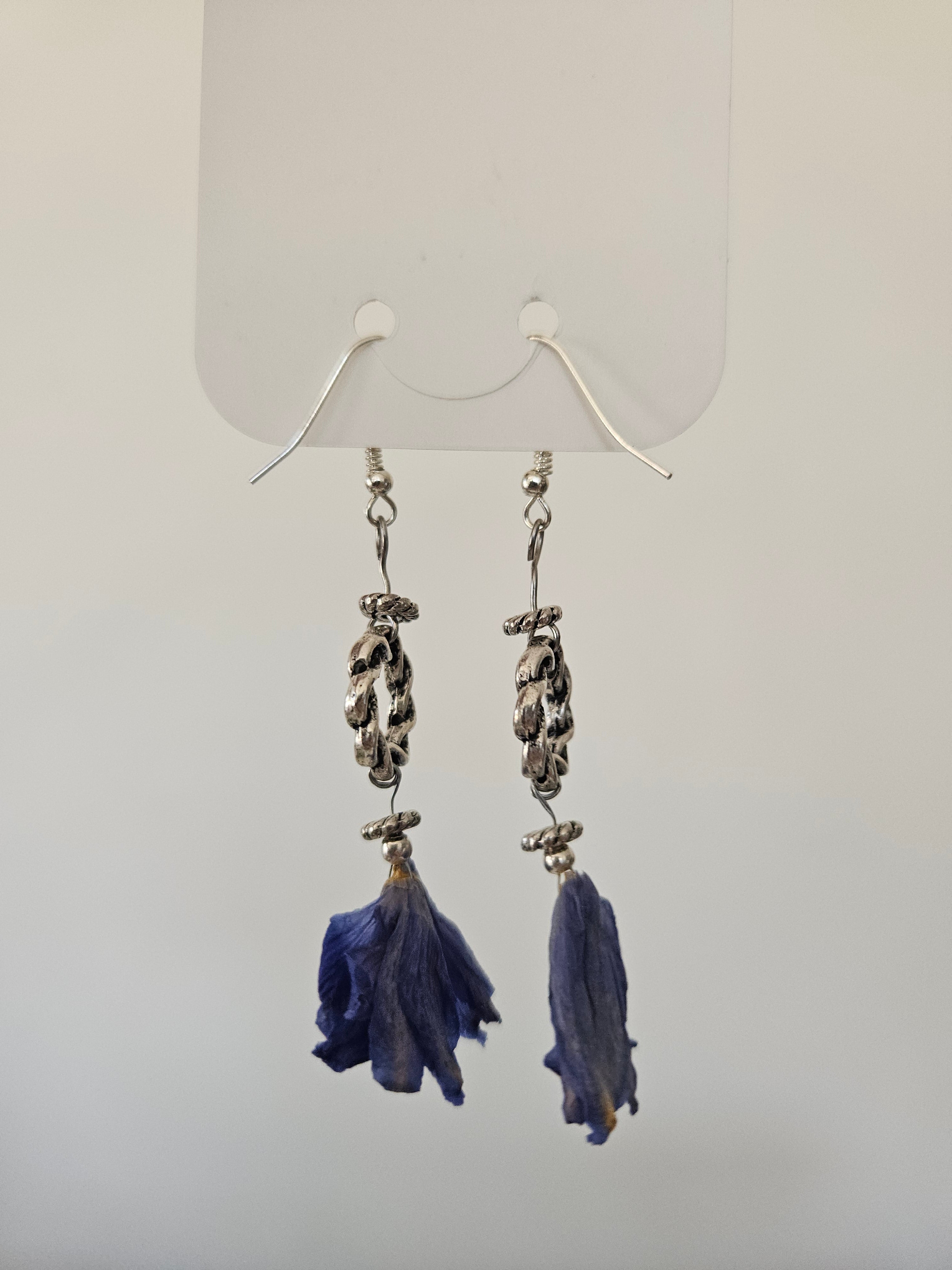 Pair of earrings with blue flowerpendants on a white background