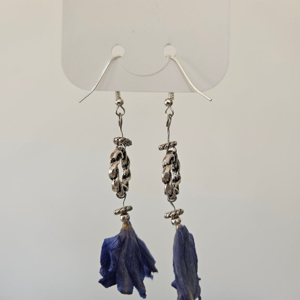 Pair of earrings with blue flowerpendants on a white background