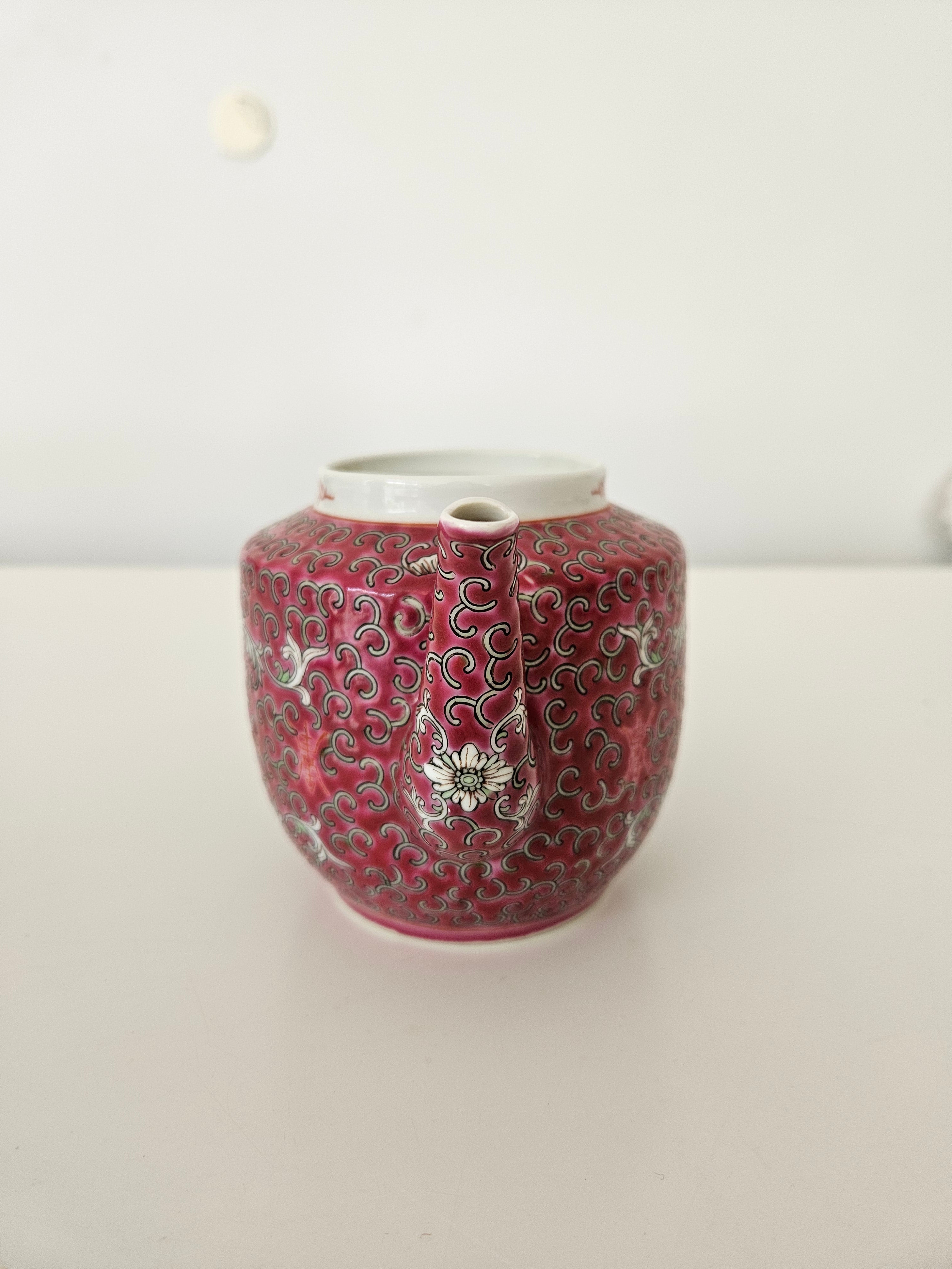 Decorative red teapot with intricate patterns on a white background