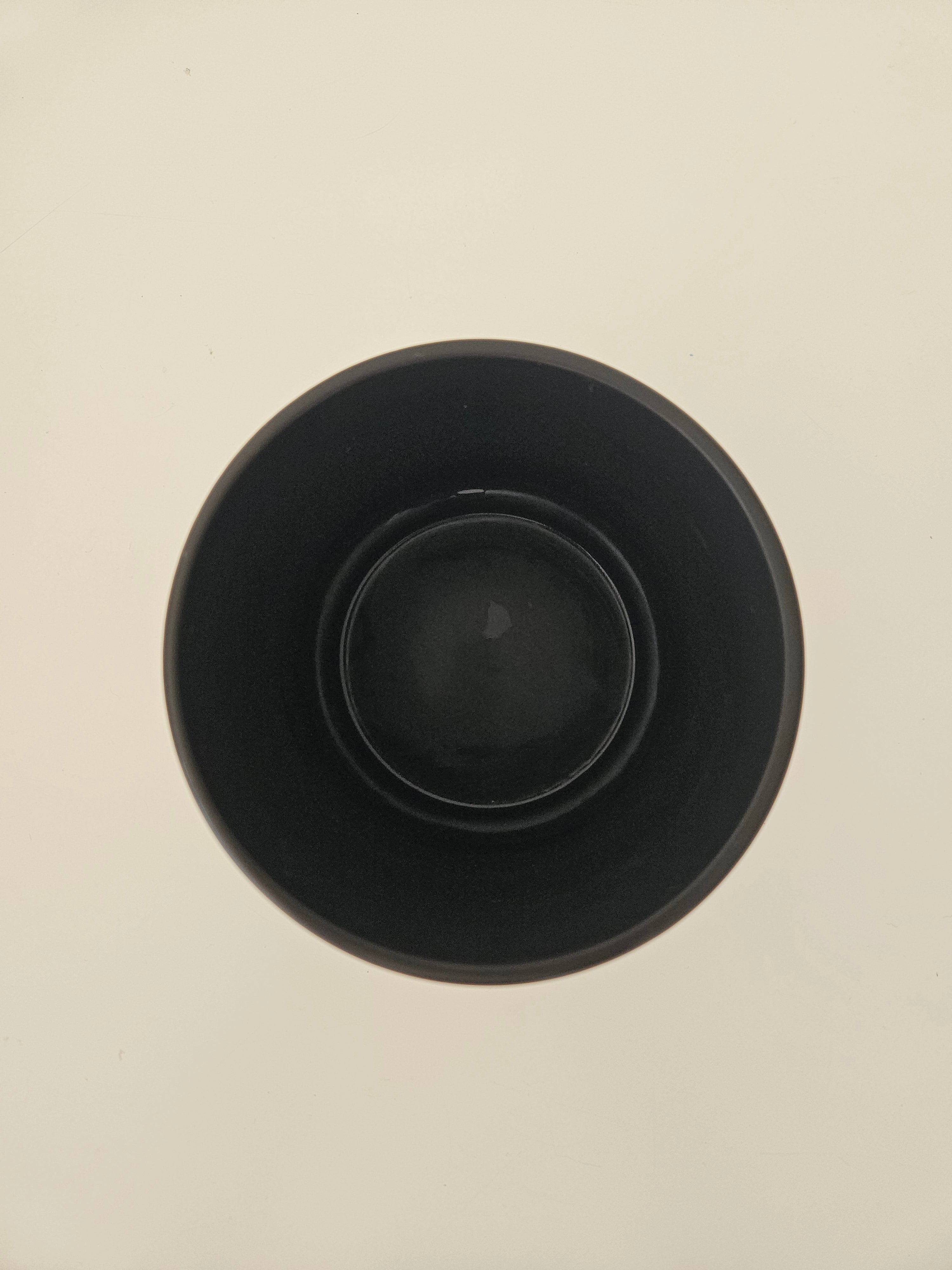 Top down view of a black pot on a white background