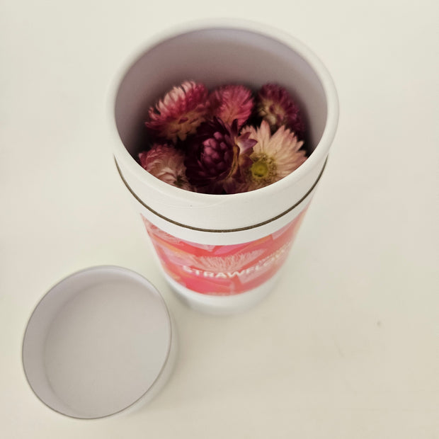 Container with dried flowers on a light background