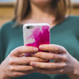woman using pink smart phone